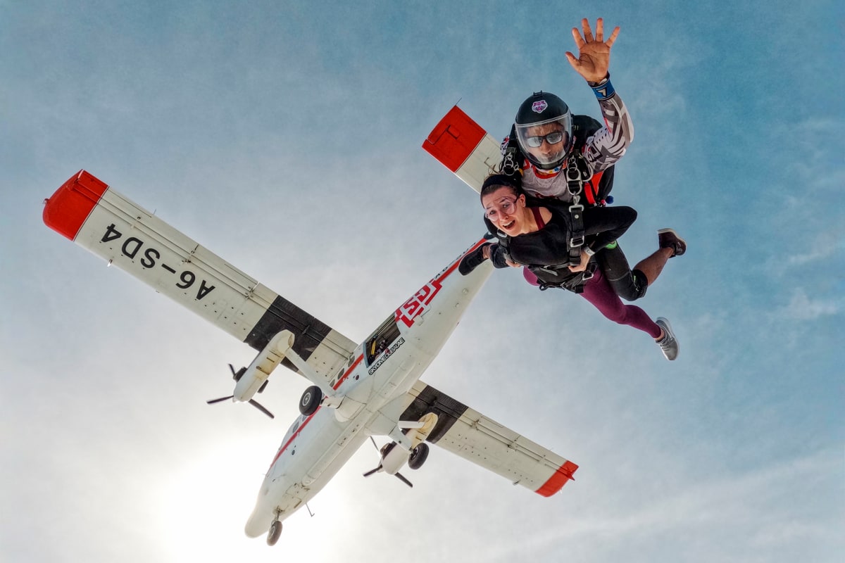 Skydiver in freefall above Palm Jumeirah with tandem instructor, showing Dubai's iconic palm-shaped islands and turquoise water (5)