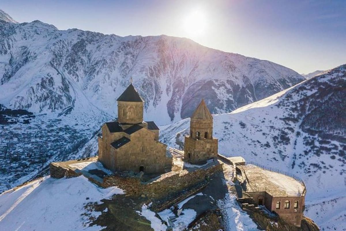 Gergeti Trinity Church against snow-covered mountains near Kazbegi, Georgia